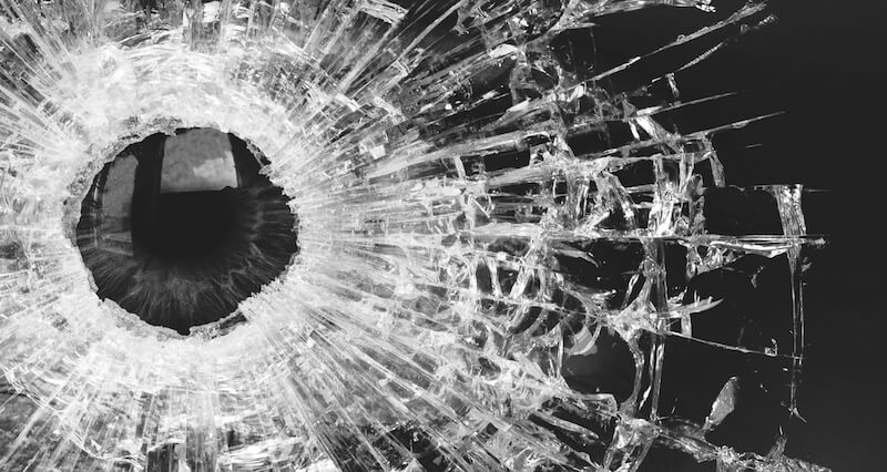 Image of a gun shot shattering glass.