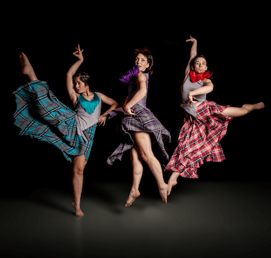 Three women jumping in the air and holding dance poses.