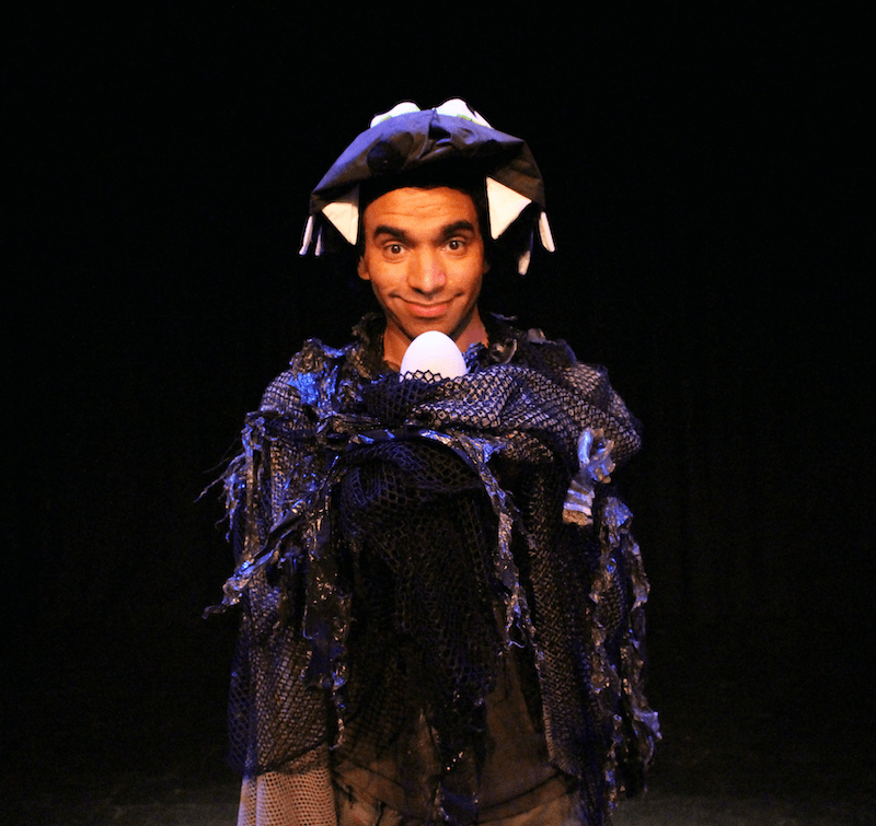 A young man dressed in costume, looking directly at the camera.